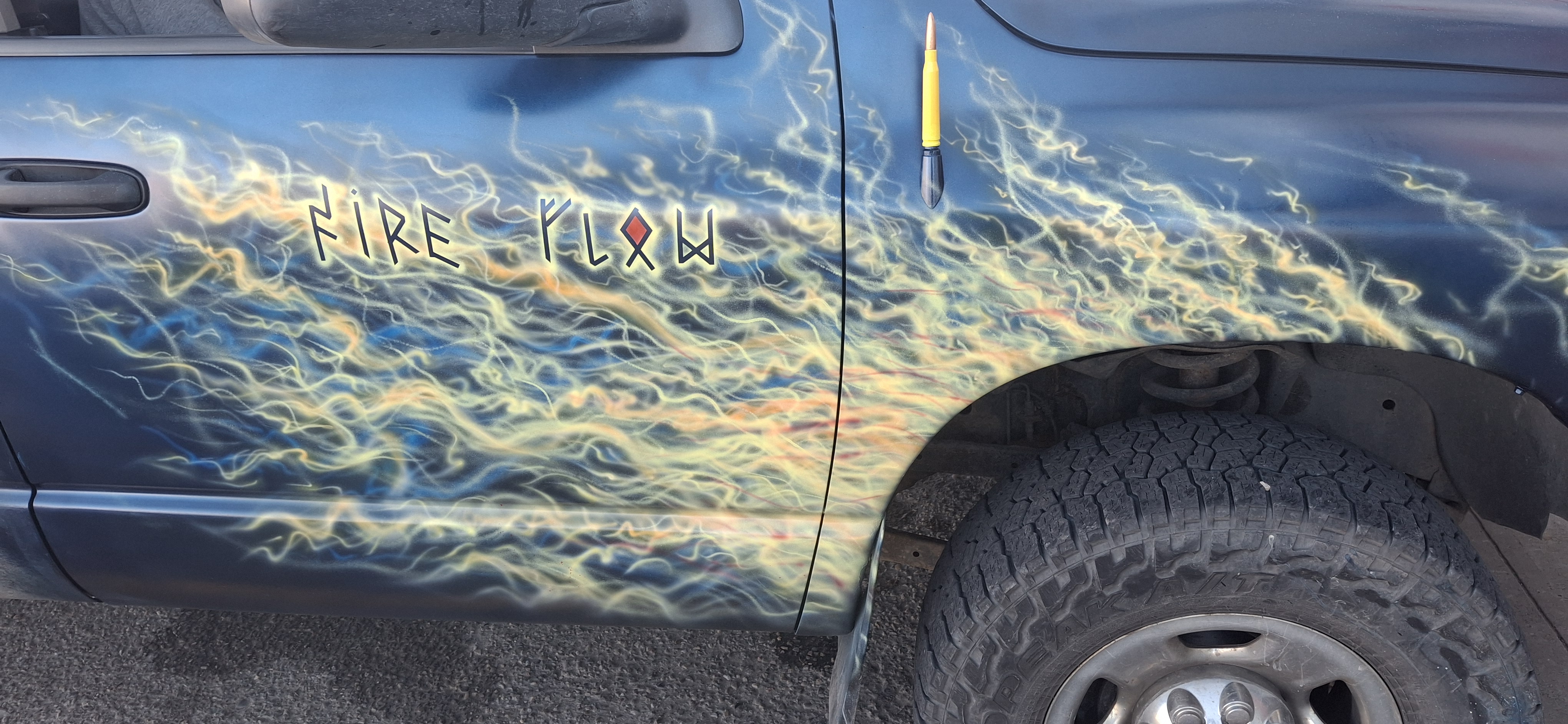 Blue and gold airbrushed flames with Fire Flow lettering on the truck's passenger side
